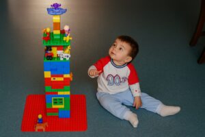 Dítě koukající na rozhlednu, která je postavena z lega.